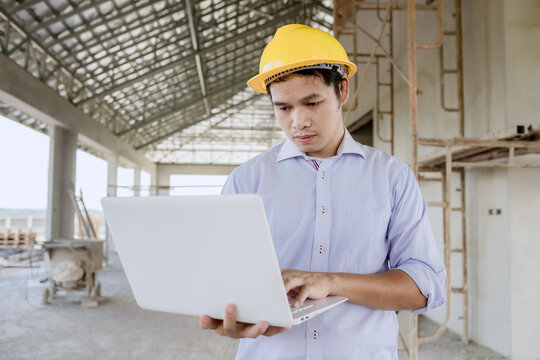 Professional engineer reviewing blueprints at industrial construction site, highlighting technology, safety, innovation, project management, and teamwork in modern engineering and manufacturing indust