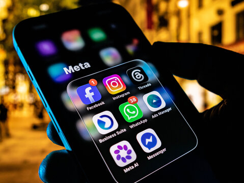 Closeup of a smartphone screen displaying various meta application icons including facebook, instagram, whatsapp, and threads