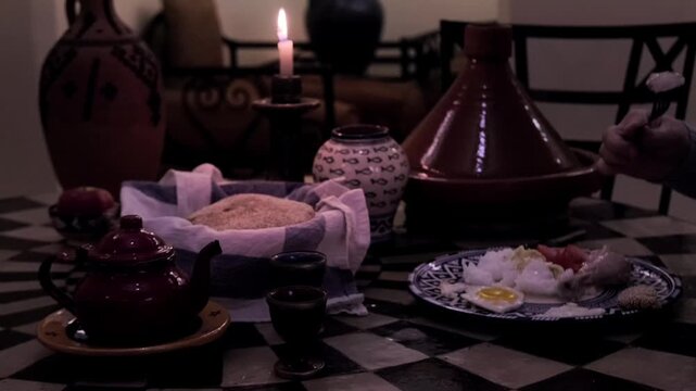 Traditional Moroccan table setting, featuring Terracotta tagine, bread, cakes, and tea, candle burning, cultural dining experience, Moroccan ceramic plates with traditional Moroccan patterns