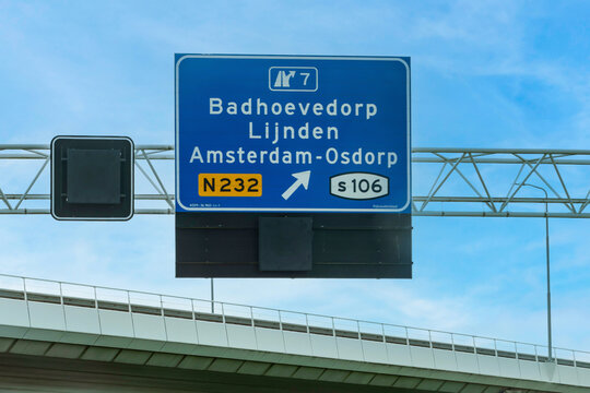 Blue overhead highway sign indicating the exit for Badhoevedorp, Lijnden, and Amsterdam Osdorp via routes N232 and s106, Netherlands