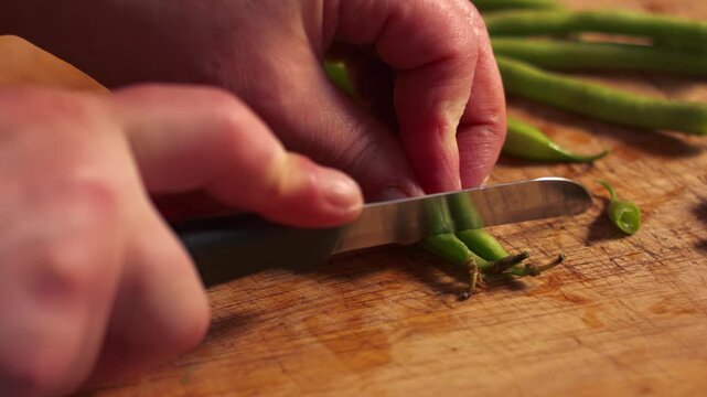 Hands chopping raw green beans
