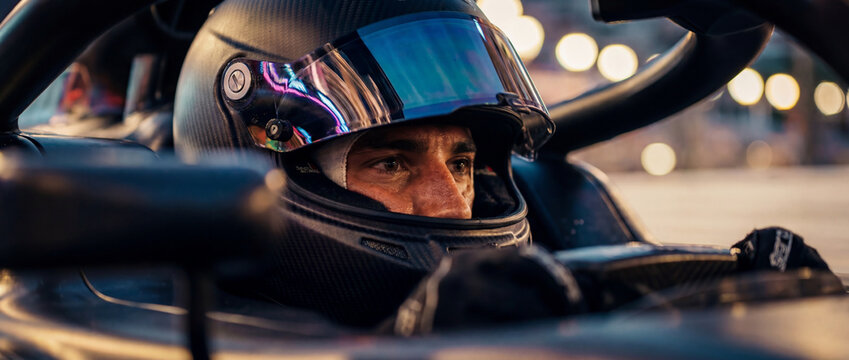 Close-up of racing driver looking through helmet visor inside open-wheel car. Concept of Formula 1 concentration, motorsport media, athlete branding and race event promo. Banner