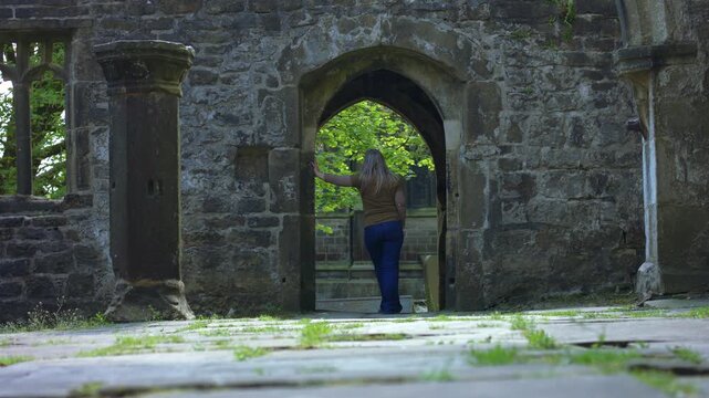 Woman tourist stands in archway of Saint Thomas a Becket Abbey Church 
