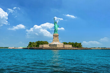 Statue of Liberty panoramic view on Liberty Island, New York with clear blue sky and Hudson River foreground. © VisualCoordinates