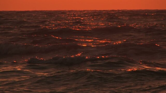 茜色の空と夕日に照らされる海面