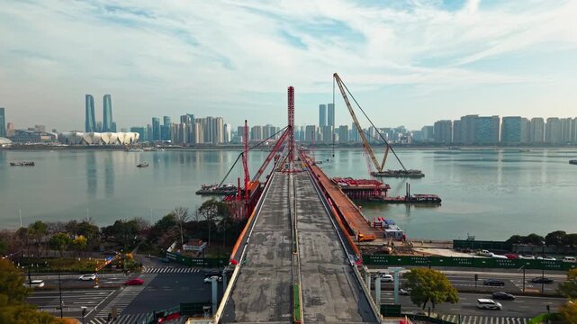 Bridge dismantling progress over river with large cranes and heavy equipment operations