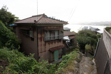 潮風が流れる坂道：遠くに海を望む、房総半島のノスタルジックな古い木造住宅 © hirota