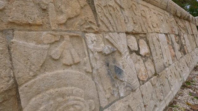 Ancient stone carvings on walls of Great Ball Court in Chichen Itza, Mexico. Detailed Mayan reliefs at historic stadium. Archaeology, heritage, culture and travel destination concept.