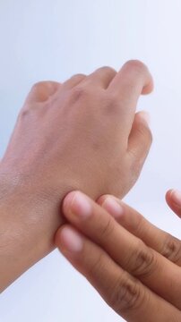 Process of applying whitening cream on left hand, then showing the difference between both hands. Skin lightening transformation, before after comparison.