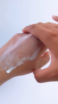 Applying whitening cream thoroughly to left hand. Skin care concept. Anti UV whitening cream for protection and brightening.