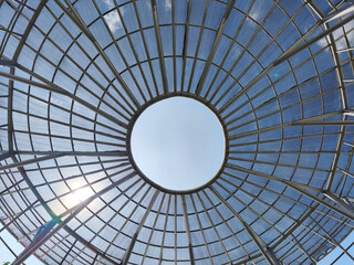 Naklejka premium The roof of the building is made of a circular iron frame, the clear sky can be seen from under the roof.