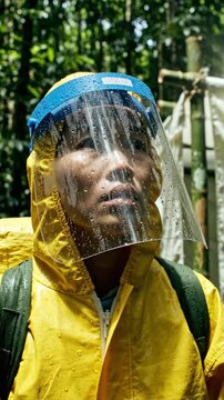 A Dedicated Researcher in Protective Gear Studies the Vibrant Biodiversity of a Lush, Tropical Rainforest Setting, Surrounded by Dense Greenery and Natural Wonders