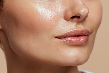 Fototapeta premium Glossy healthy skin texture close up face with natural lip shine and smooth cheek skin