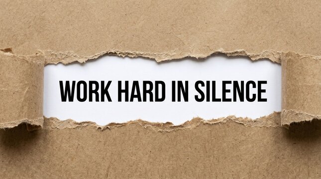 Work hard message printed on white paper revealed through a torn brown cardboard sheet in this conceptual studio photograph for business motivation and personal growth.
