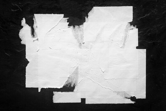Old torn city poster on black background close-up