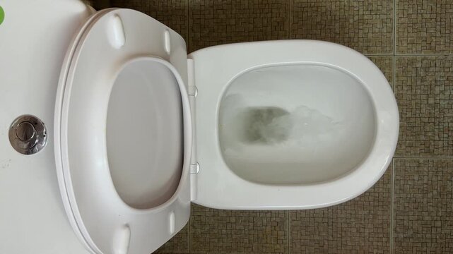 Flushing action of flush toilet bowl with water, top view