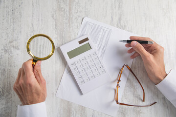 Naklejka na ściany i meble Businessman using calculator and working in financial document.