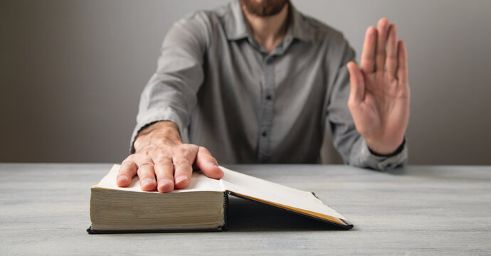 Man taking oath with hand on book.