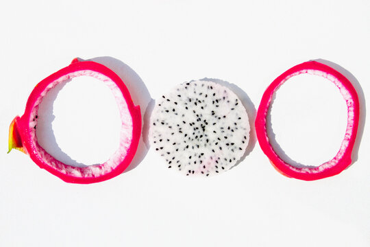 Dragon fruit slices with peel circles white background close up