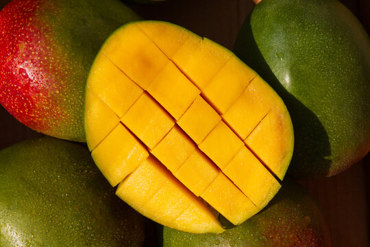 Close Up Mango Cubes in Peel with Fresh Mangoes