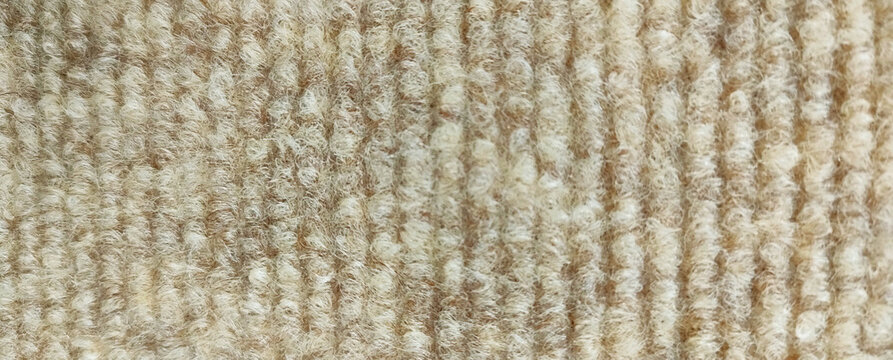 Close-up texture of beige and brown loop pile carpet background
