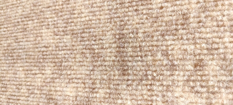 Close-up texture of beige and brown loop pile carpet background
