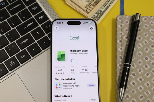 Kiel, Germany - 05-20-2026: Smartphone displaying the Microsoft Excel spreadsheet and data analysis app in the App Store in a workspace environment with laptop and notebook
