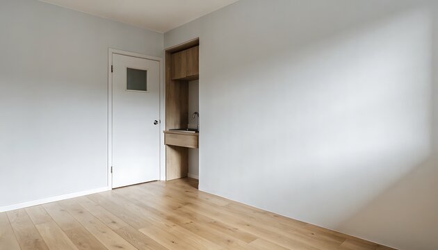 Empty room with light blue walls, a white door with a small window, and a wooden floor, featuring a built-in wooden cabinet with a sink and