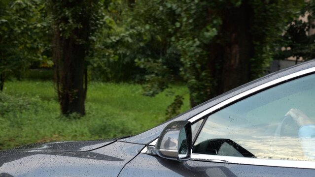 Modern electrical automobile driving at urban road on rainy day. Ecology friendly car riding moving along motorway. Electric vehicle riding through empty highway. Concept of green innovation. Slow mo