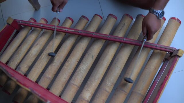 Traditional Balinese musician playing bamboo rindik gamelan