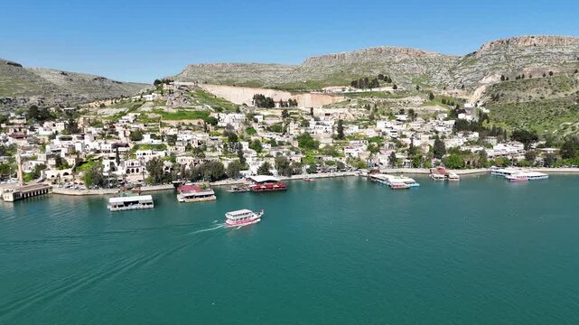 Aerial drone view of Halfeti ancient town and tourist tour boat on Euphrates river in Sanliurfa, Turkey
