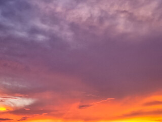 Obraz premium Soft colorful sunset sky with glowing orange clouds and dreamy purple evening atmosphere