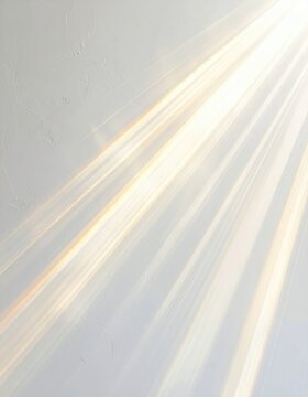 Diagonal golden light rays stream across a textured white wall