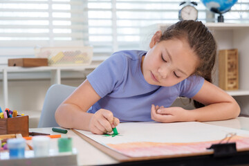 Naklejka premium Caucasian girl preteen coloring large artwork paper green crayon during elementary classroom art lesson concentrating creativity practice childhood learning study education discipline