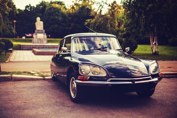 Fototapeta premium Vintage luxury car parked in urban park setting