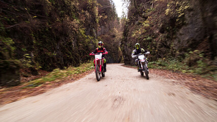 Fototapeta premium Bikers riding enduro motorcycles on mountain gravel road