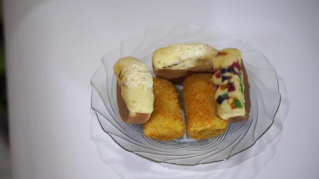 Assorted Indonesian traditional snacks featuring pukis cake and risoles served on a glass plate.