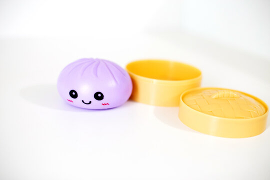 Squishy dumpling toy on white background with steamer basket