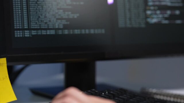 Close up view of a desktop computer screen displaying complex software database coding lines and a digital interface layout during a tech startup session.