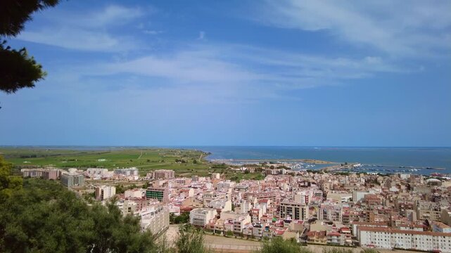Breathtaking high angle view revealing the coastal fishing village of Sant Carles de la Rapita, the marina, and the Mediterranean Sea in the Ebro Delta natural park on a sunny day
