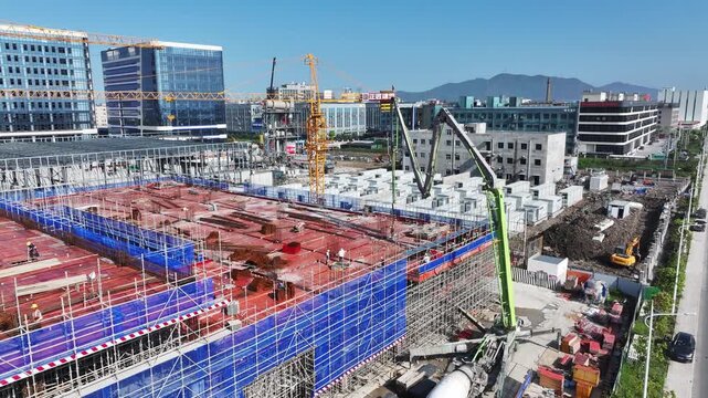 Urban construction site with tower cranes and high-rise building framework under development