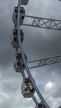 Modern ferris wheel with glass cabins against a cloudy sky