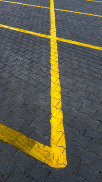 Symmetrical parking lot lines on a textured pavement with yellow marking