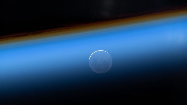 blue ozone layer of planet earth. distant silhouette of the full moon. satellite point of view. NASA Public Domain Imagery