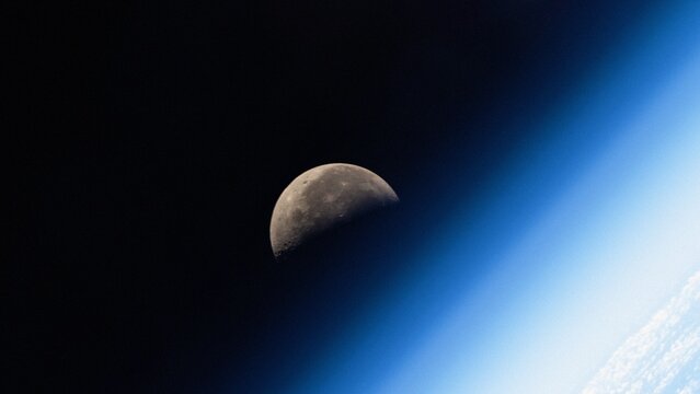 Blue ozone layer of planet Earth. Distant silhouette of the moon. Satellite point of view. NASA Public Domain Imagery