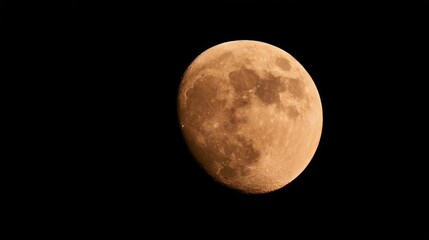 Fototapeta premium Orange Moon reflecting earthlight in dark night sky, revealing textured surface and visible craters