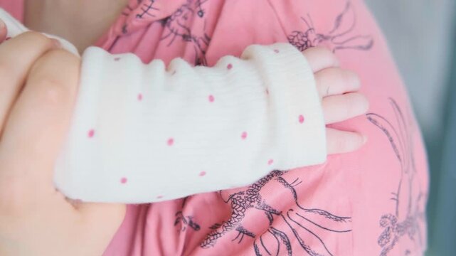 Tiny Newborn Baby Hand Resting on Mother Shoulder, Loving Embrace and Bond. Sweet Infant Cuddling and Hugging Mother, Concept of Motherhood, Tender Care, Protection and Family Love