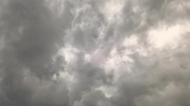Heavy clouds fill the sky as a storm begins. Dark shades cover the atmosphere. The weather changes quickly, suggesting rain and lightning are on the way. People may seek shelter soon.