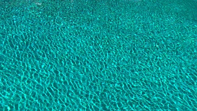 Moving patterns formed by shimmering blue water. Backgrounds.