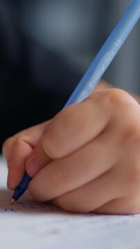 Close-up images of a person focused on writing with a blue pen on paper, capturing the hand in action and the blurred face behind glasses demonstrating concentration and creativity